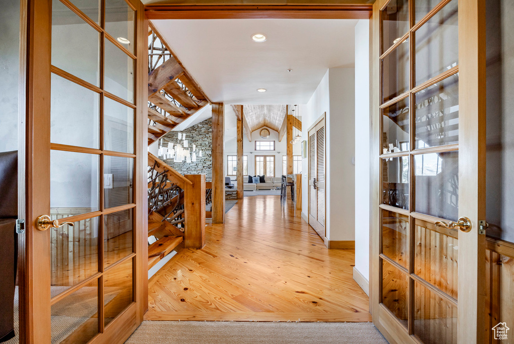 Entryway with french doors, wood finished floors, lofted ceiling, baseboards, and recessed lighting