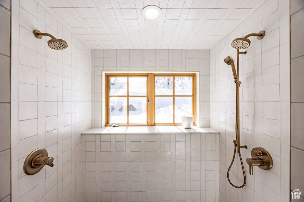 Bathroom with tiled shower and tile walls