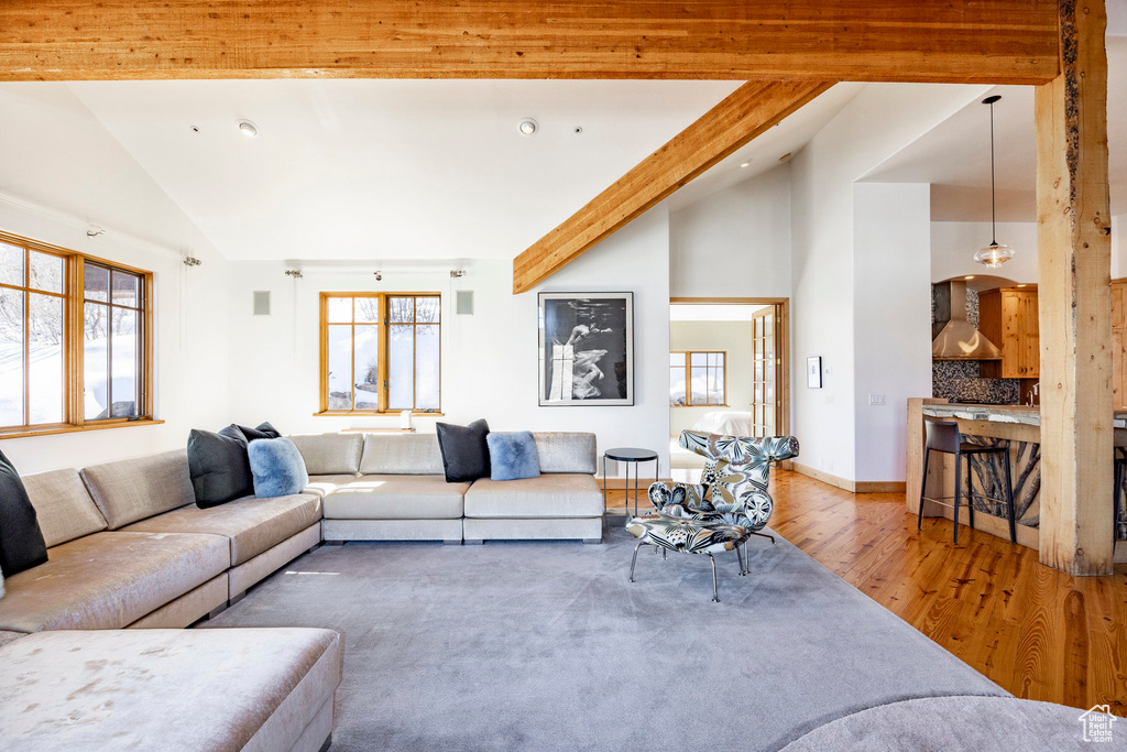 Living area with wood finished floors, beamed ceiling, high vaulted ceiling, and recessed lighting