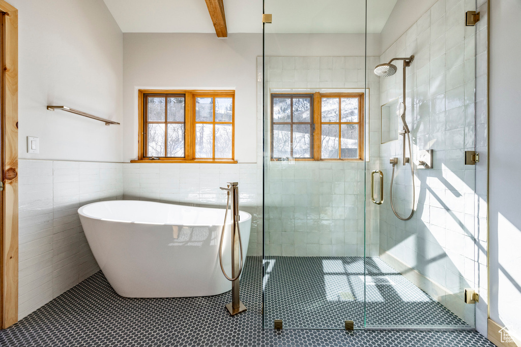 Full bathroom with tile walls, a freestanding tub, a stall shower, plenty of natural light, and tile patterned floors