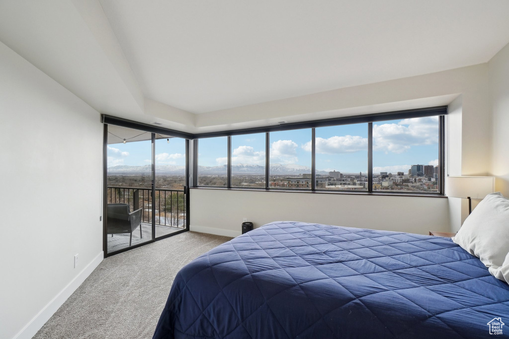 Carpeted bedroom featuring access to outside, a view of city, and baseboards