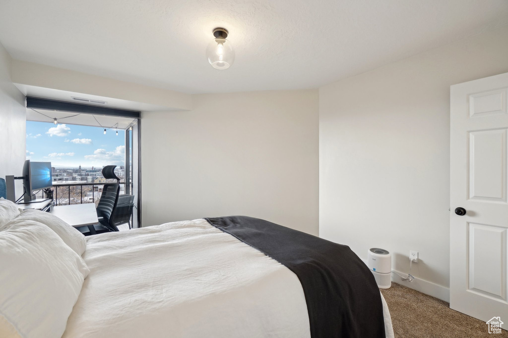 Bedroom with access to exterior, carpet, visible vents, and baseboards