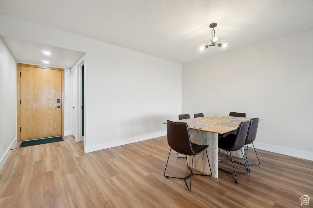 Dining room featuring a chandelier, light wood-style flooring, and baseboards