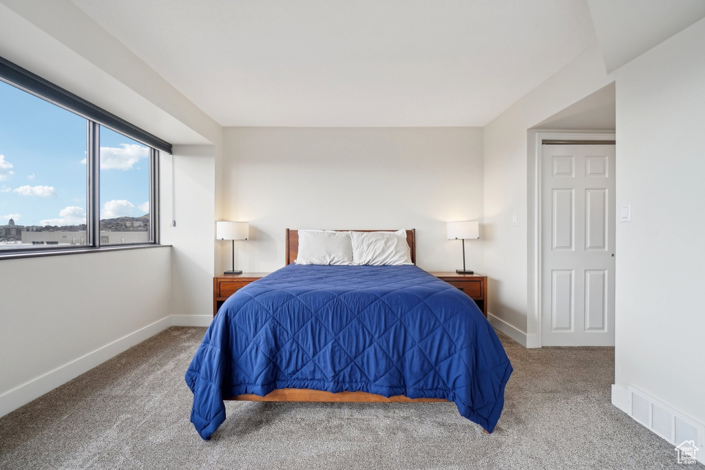 Carpeted bedroom featuring visible vents and baseboards