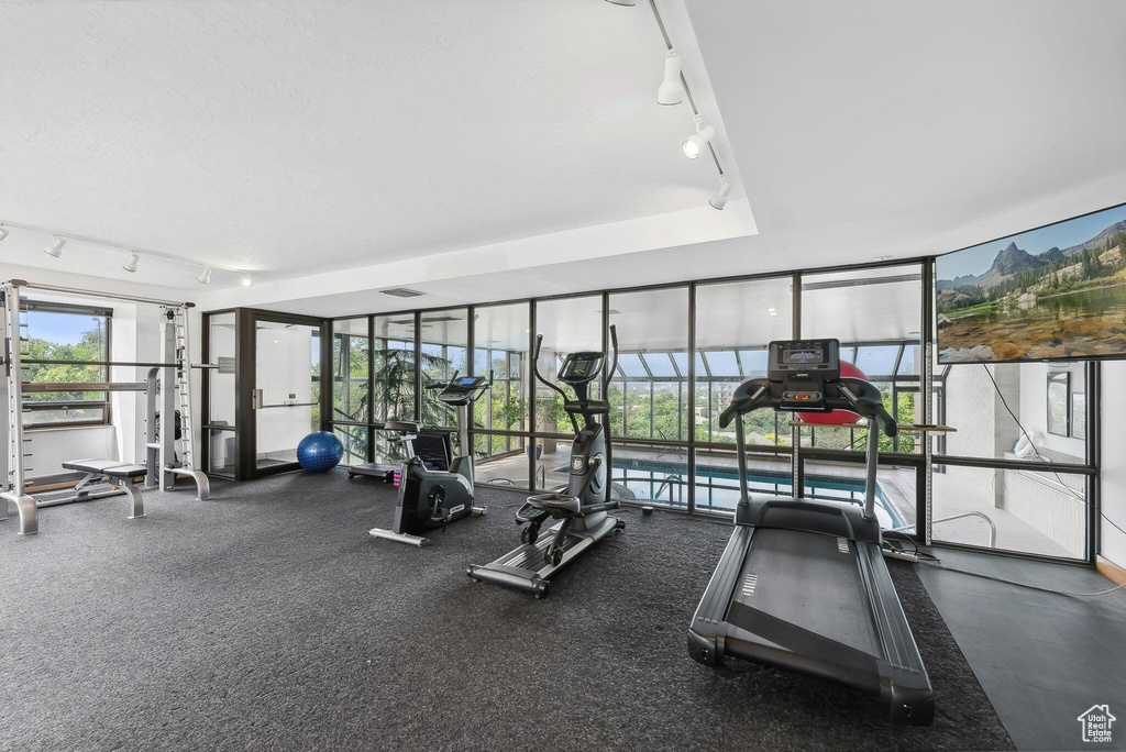 Gym with expansive windows, visible vents, and track lighting