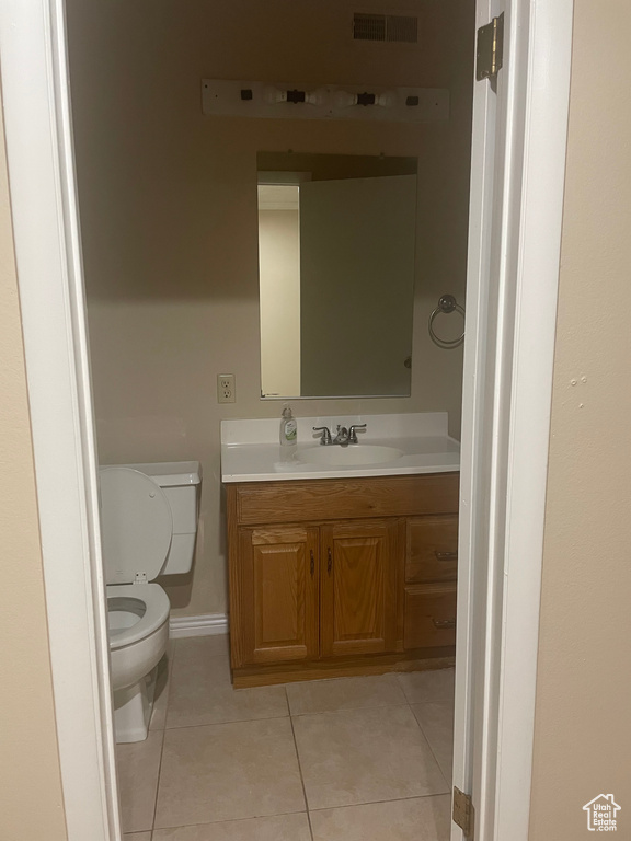 Bathroom featuring toilet, vanity, and tile patterned flooring