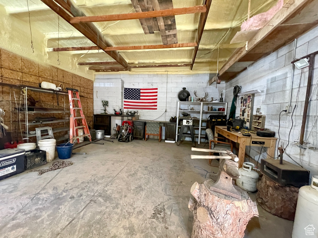 Misc room with concrete block wall, concrete floors, and a workshop area