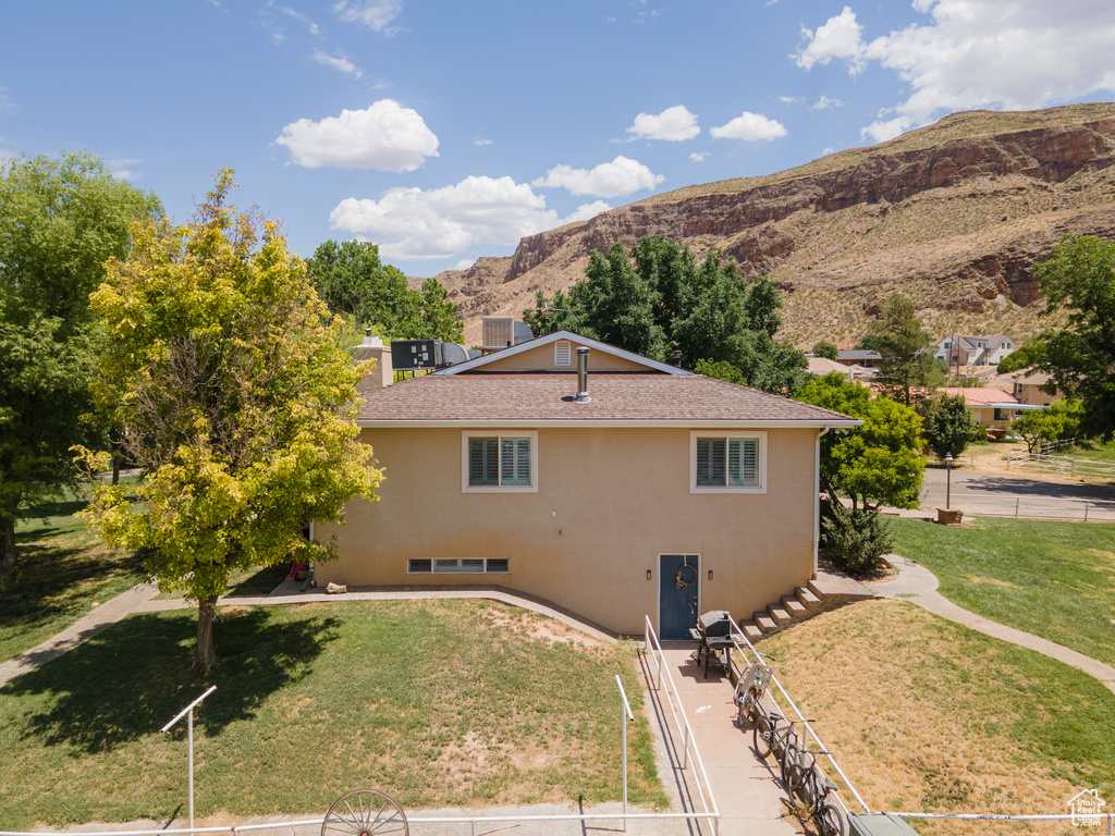 View of home\\\\\\\'s exterior with a mountain view and a lawn