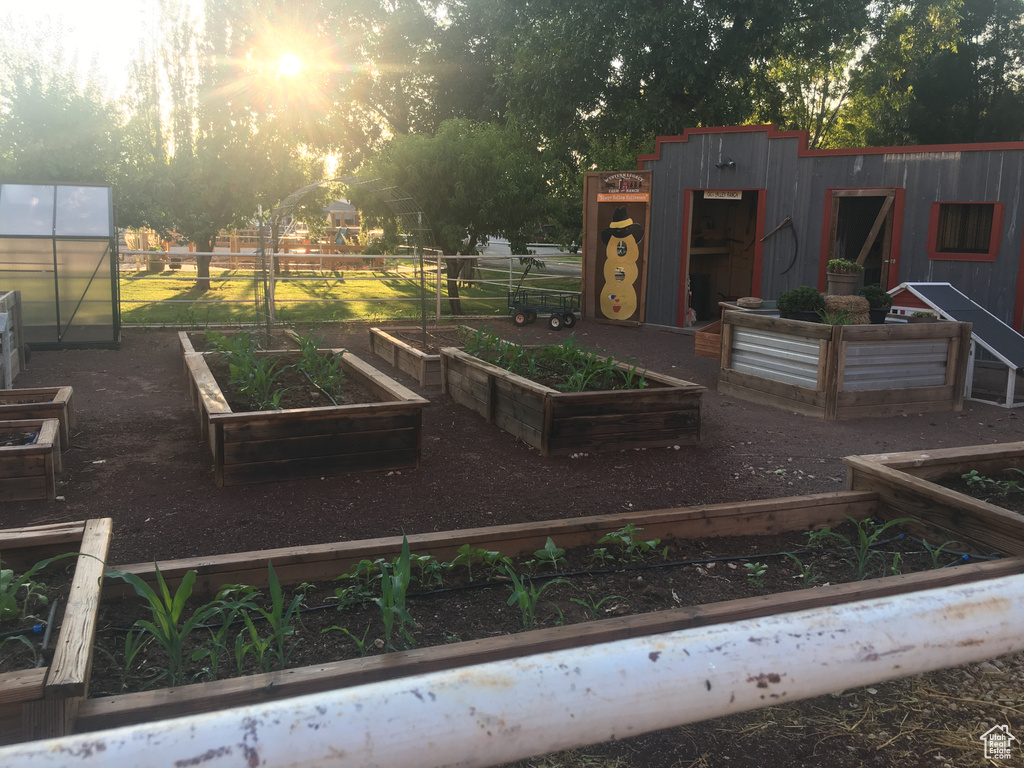 View of yard featuring an outbuilding, a vegetable garden, and a greenhouse