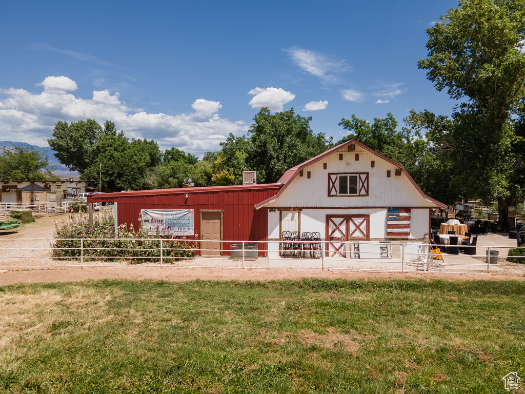 Rear view of property featuring a yard and an outdoor structure