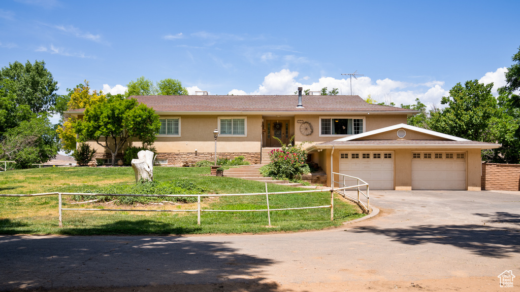 View of front facade with a front yard and a garage