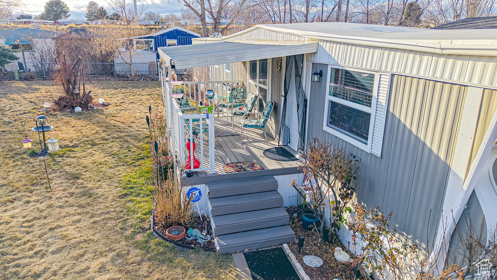 View of side of home with a yard and a deck