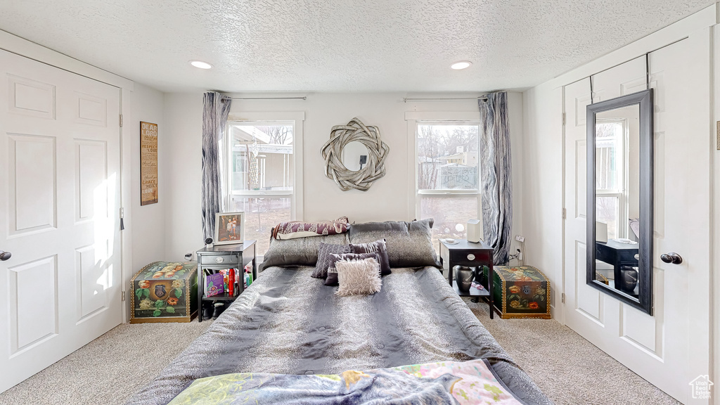 Bedroom featuring light carpet and a textured ceiling