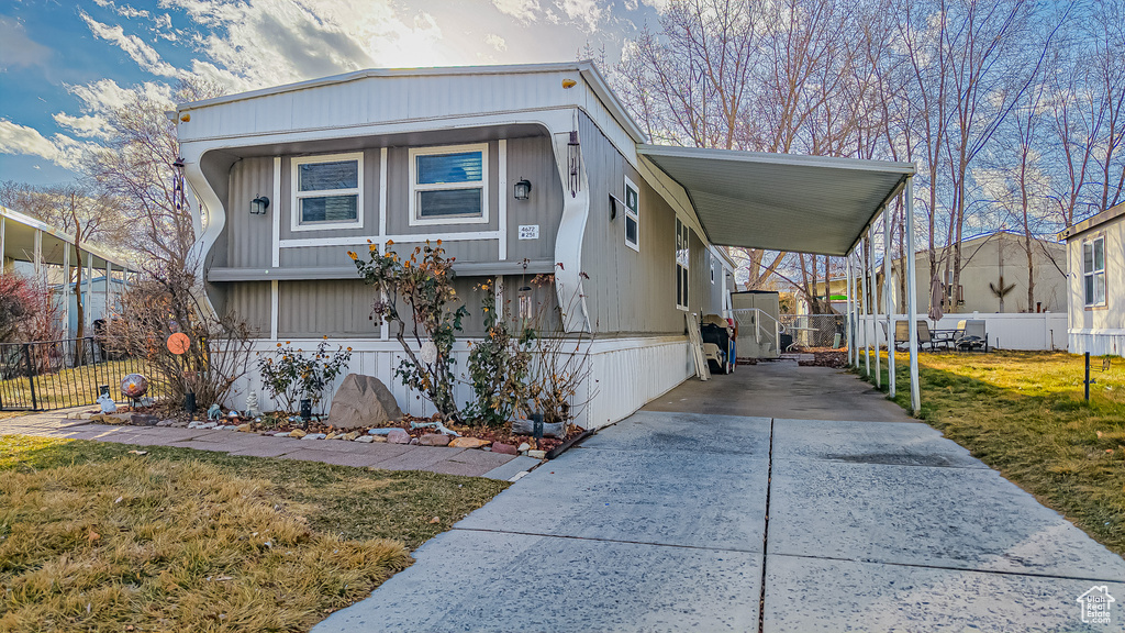 View of front of house with a front yard and a carport