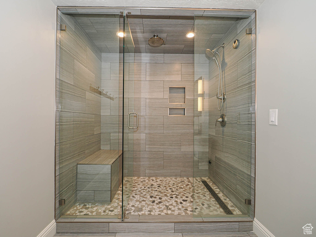 Bathroom featuring a stall shower and baseboards