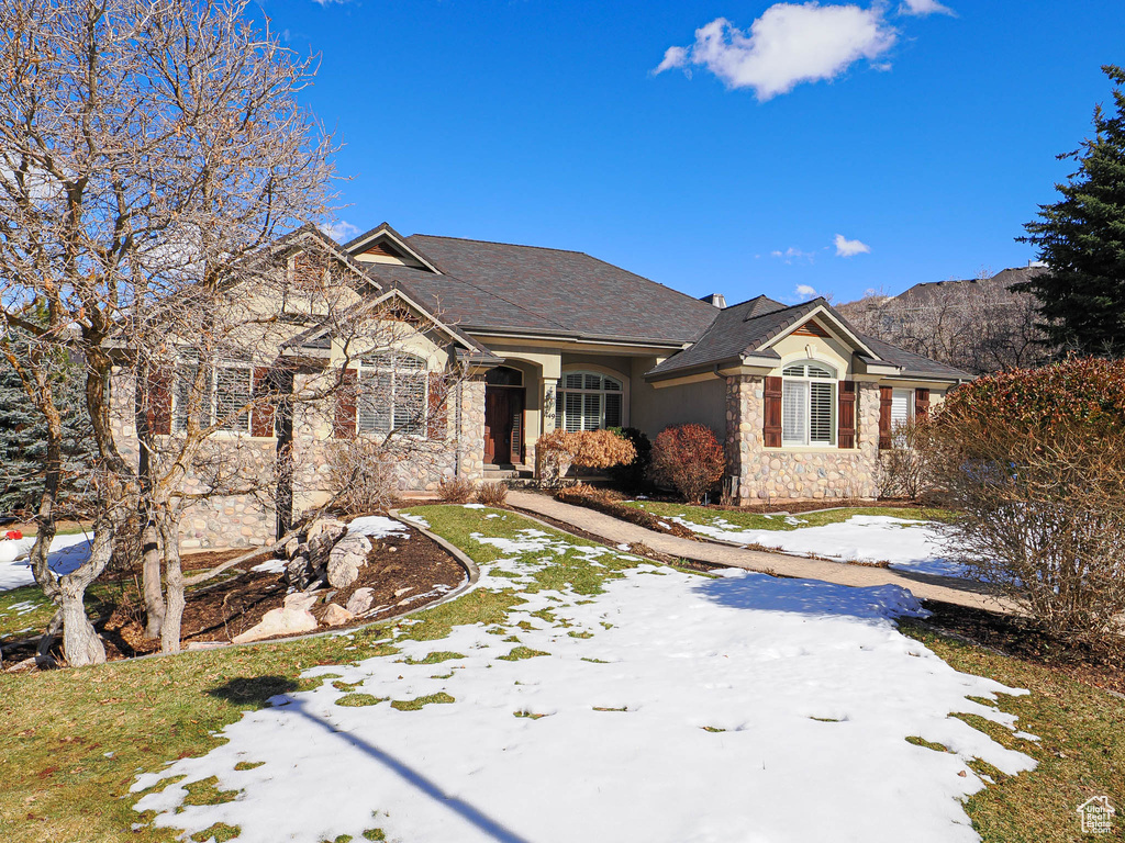 View of front of home with stone siding and a mountain view