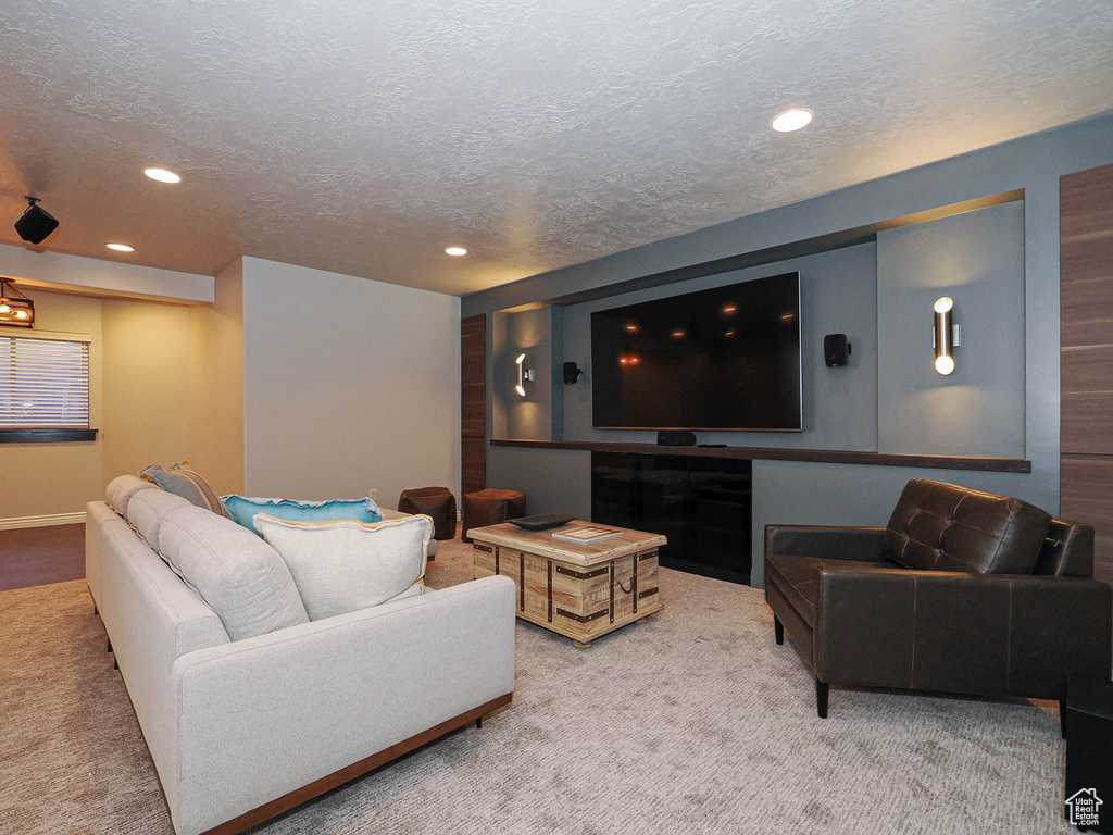 Living area with a textured ceiling, carpet, and recessed lighting