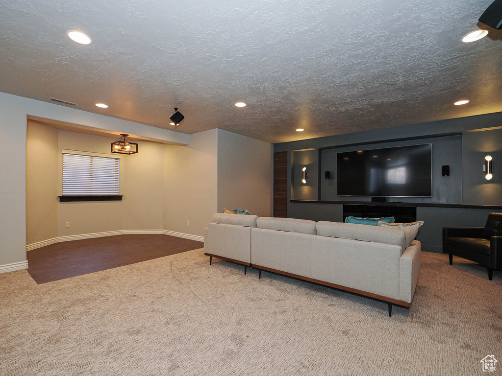 Carpeted living area with recessed lighting, visible vents, a textured ceiling, and baseboards