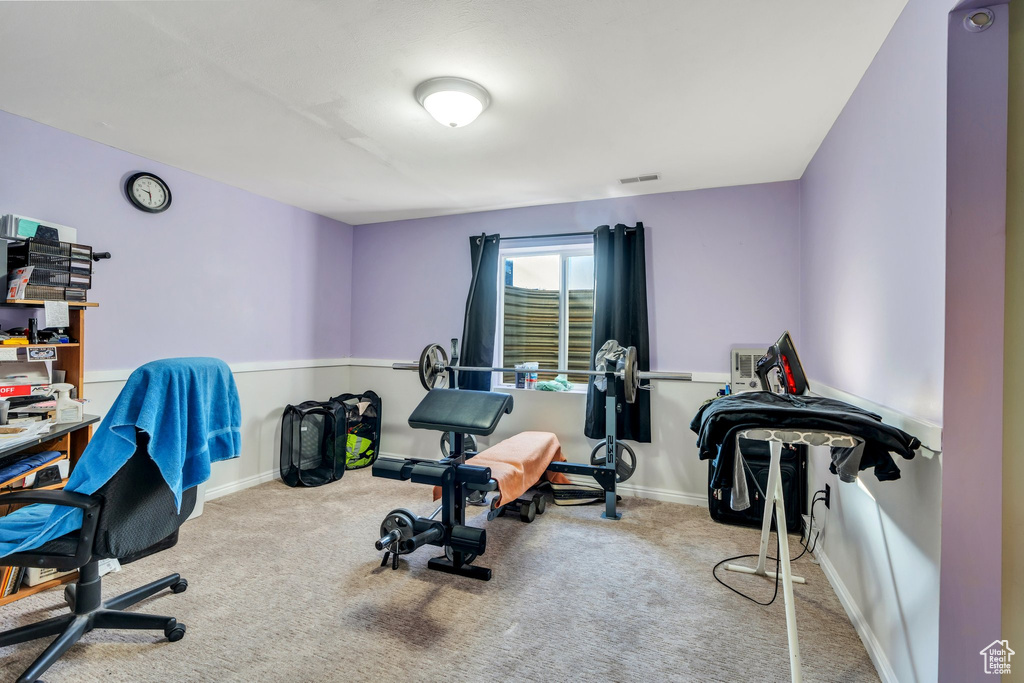 Exercise room featuring light carpet, visible vents, and baseboards