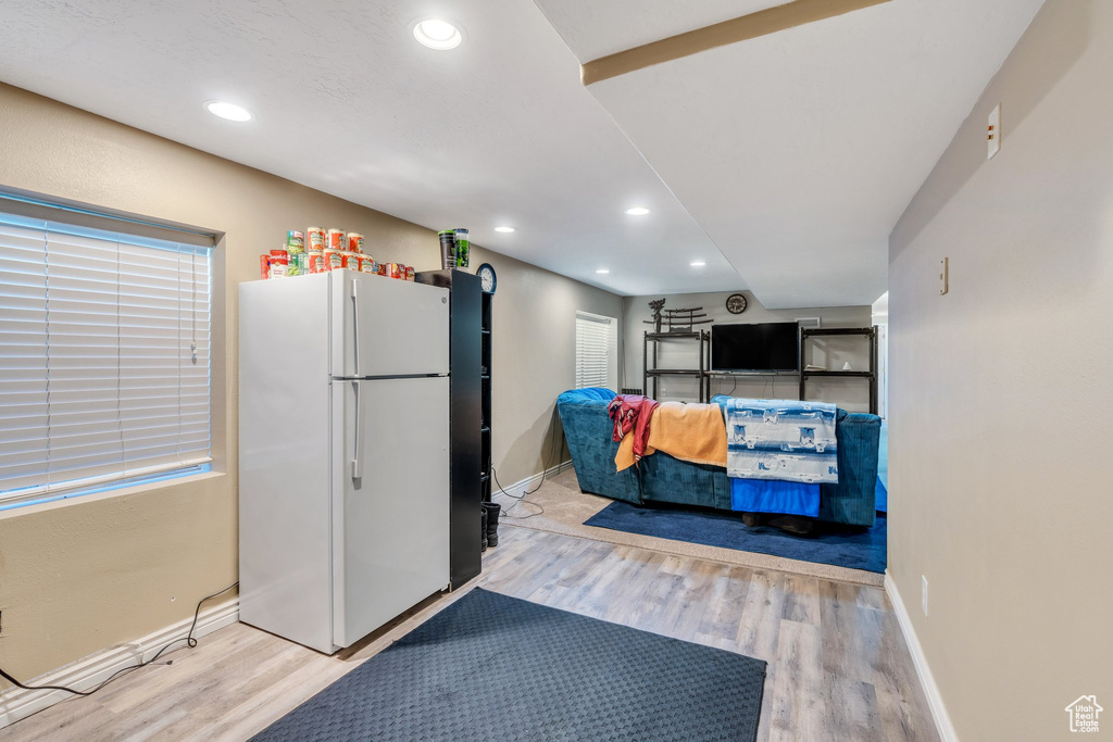 Kitchen with freestanding refrigerator, recessed lighting, baseboards, and wood finished floors