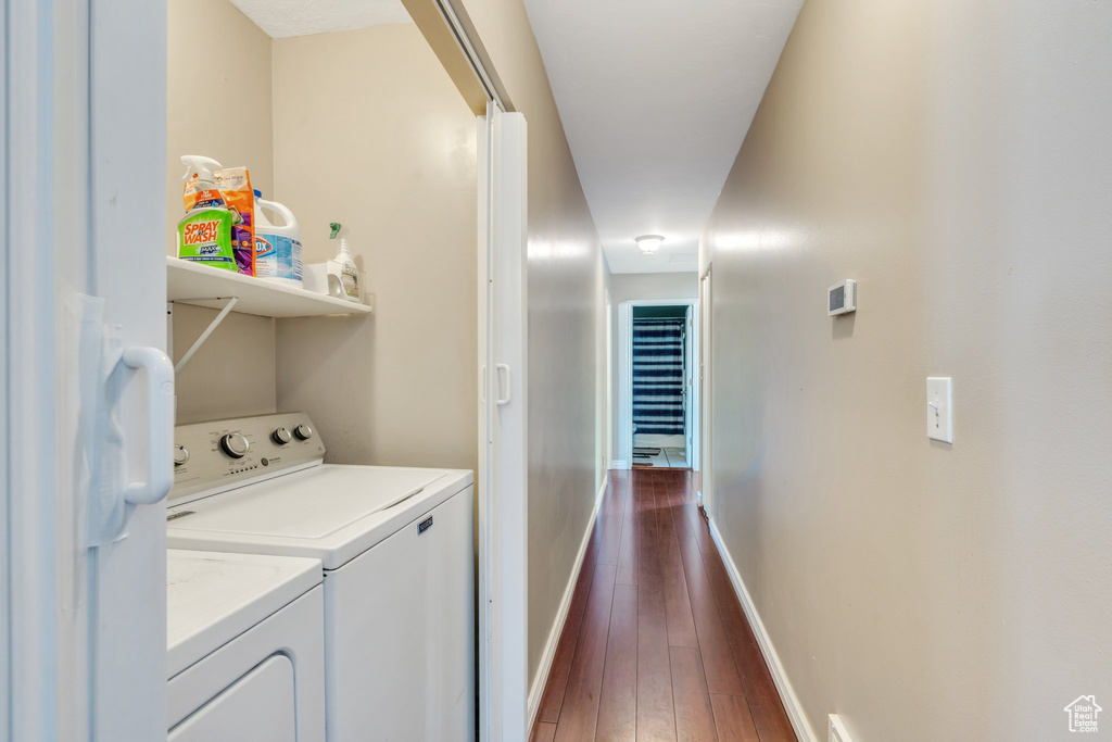 Laundry area featuring washer and dryer, laundry area, dark wood finished floors, and baseboards