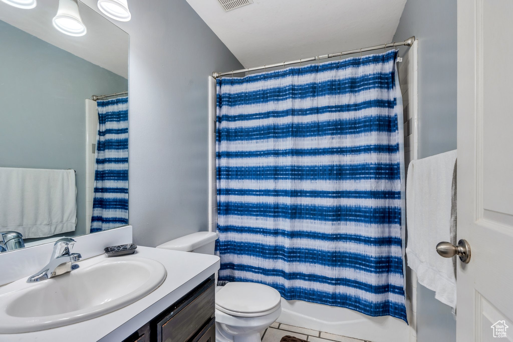 Bathroom featuring shower / bath combo, visible vents, toilet, tile patterned flooring, and vanity