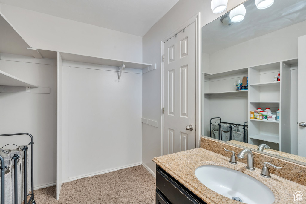 Bathroom featuring a closet, vanity, and baseboards