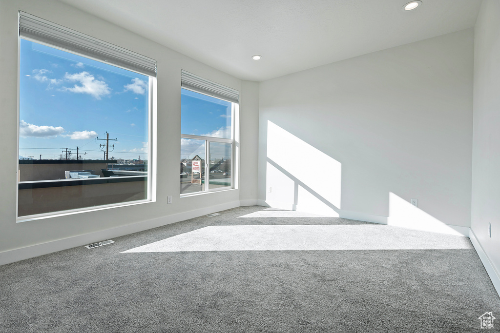 Carpeted empty room with recessed lighting, visible vents, and baseboards