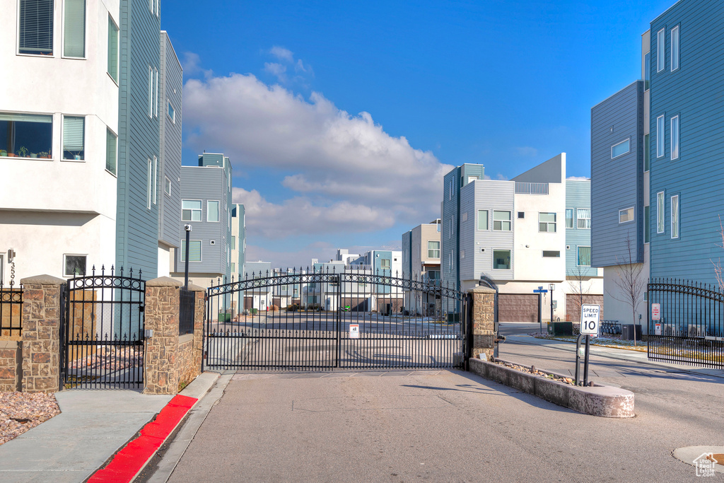 View of road with sidewalks, a gate, a gated entry, and curbs