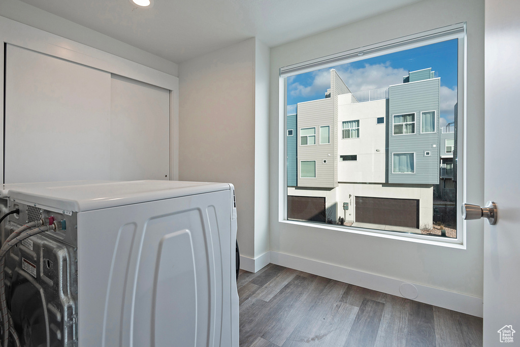 Clothes washing area featuring laundry area, baseboards, washer / clothes dryer, and wood finished floors