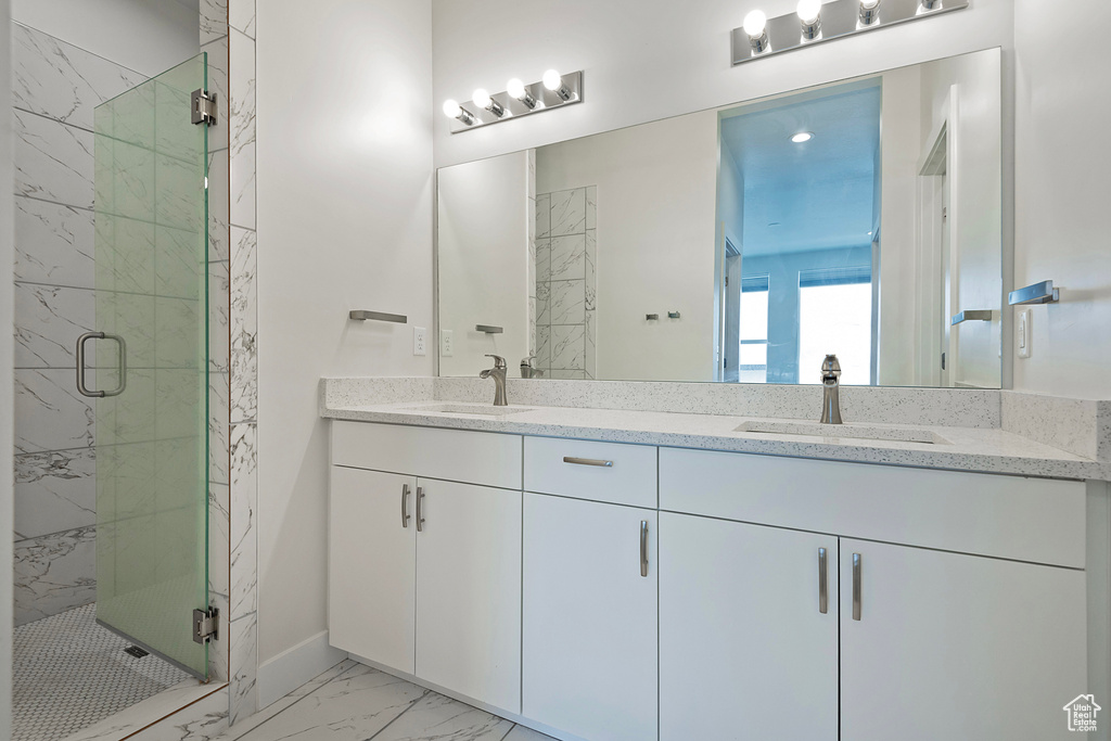 Full bath with marble finish floor, double vanity, a sink, and a marble finish shower