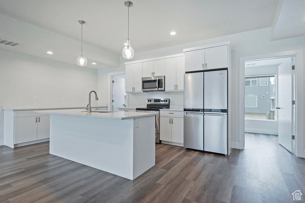 Kitchen featuring visible vents, appliances with stainless steel finishes, white cabinets, and a sink