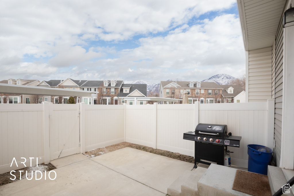 View of patio / terrace with a residential view, a fenced backyard, a grill, and a mountain view