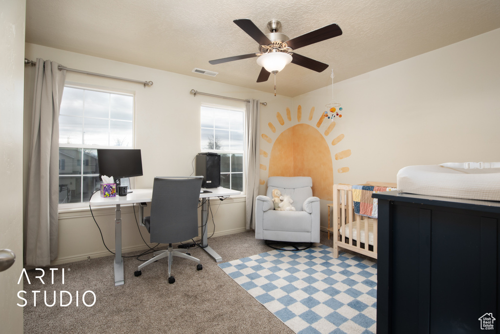 Carpeted office with visible vents, ceiling fan, a textured ceiling, and baseboards