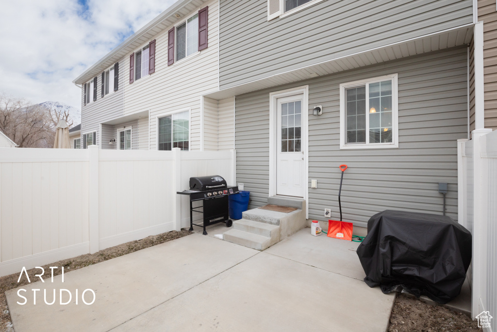View of patio featuring a grill and fence