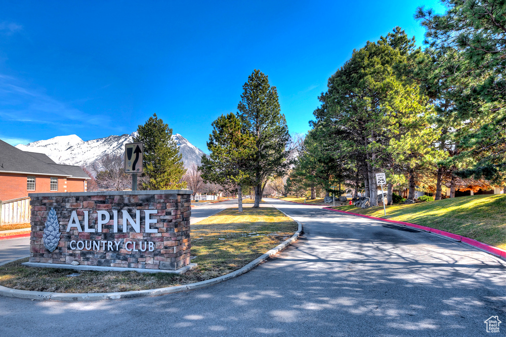 Community sign with a mountain view and a yard