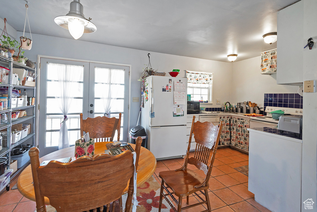 Dining room featuring light tile patterned floors and french doors