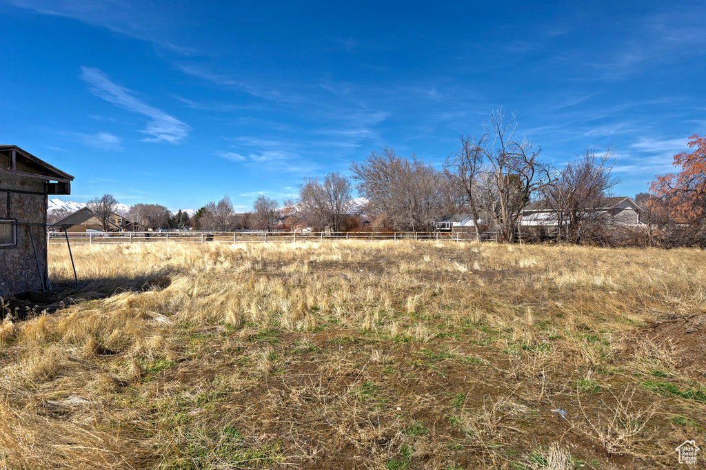 View of yard featuring a rural view and fence