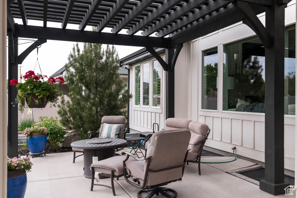 View of patio with a fire pit and a pergola