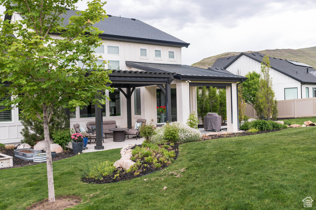 Rear view of house featuring outdoor lounge area, a patio area, a standing seam roof, metal roof, and a pergola