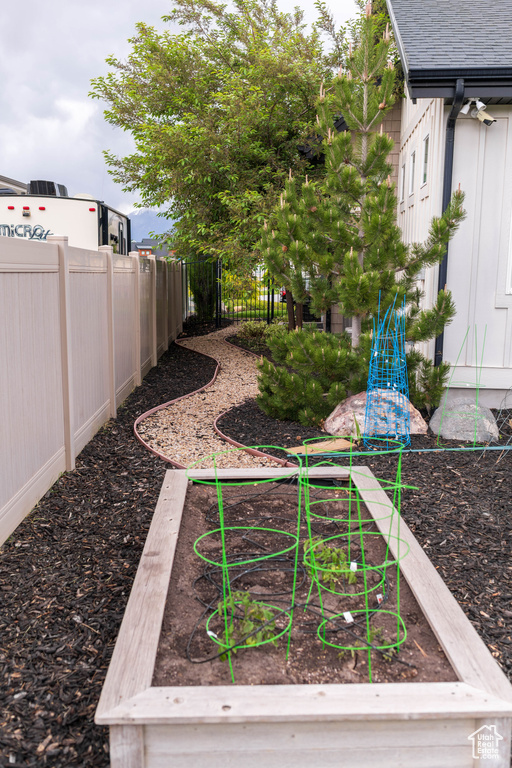 View of yard featuring a vegetable garden and fence