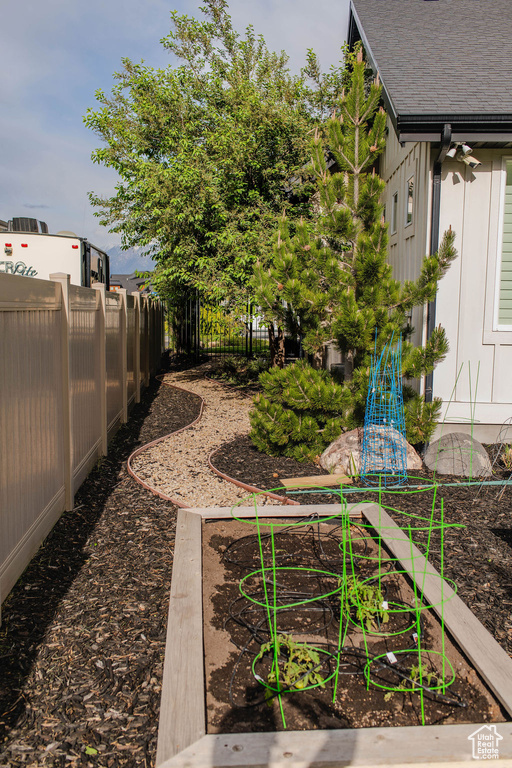 View of yard with a garden and fence