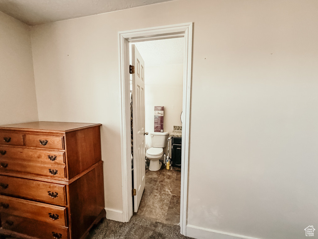 Hall with dark carpet and baseboards