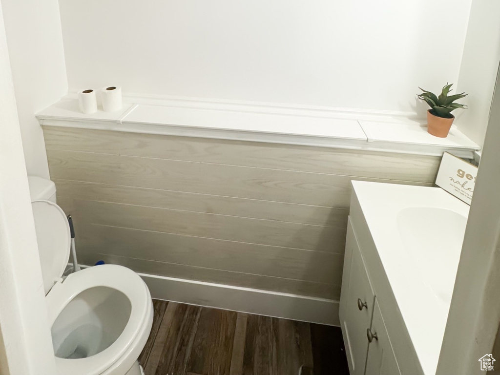 Bathroom with a textured ceiling, wood finished floors, vanity, and visible vents