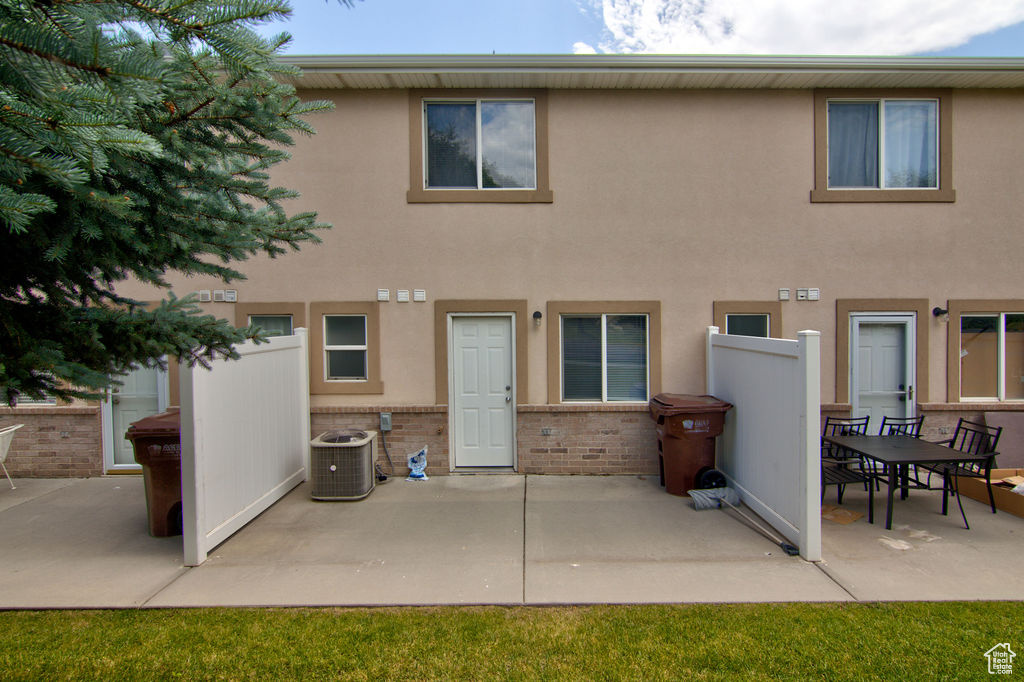Rear view of house with a patio, brick siding, and stucco siding