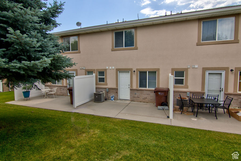 Rear view of house with a patio area, brick siding, a yard, and stucco siding