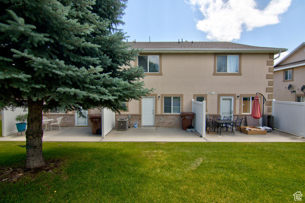 Rear view of property featuring a patio area, brick siding, and stucco siding