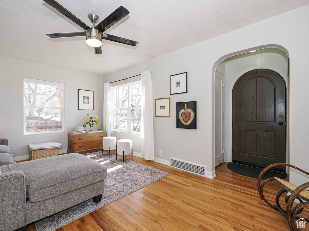 Interior space with arched walkways, wood finished floors, visible vents, and baseboards