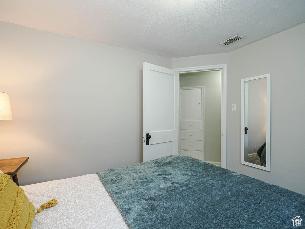 Bedroom with visible vents and a textured ceiling