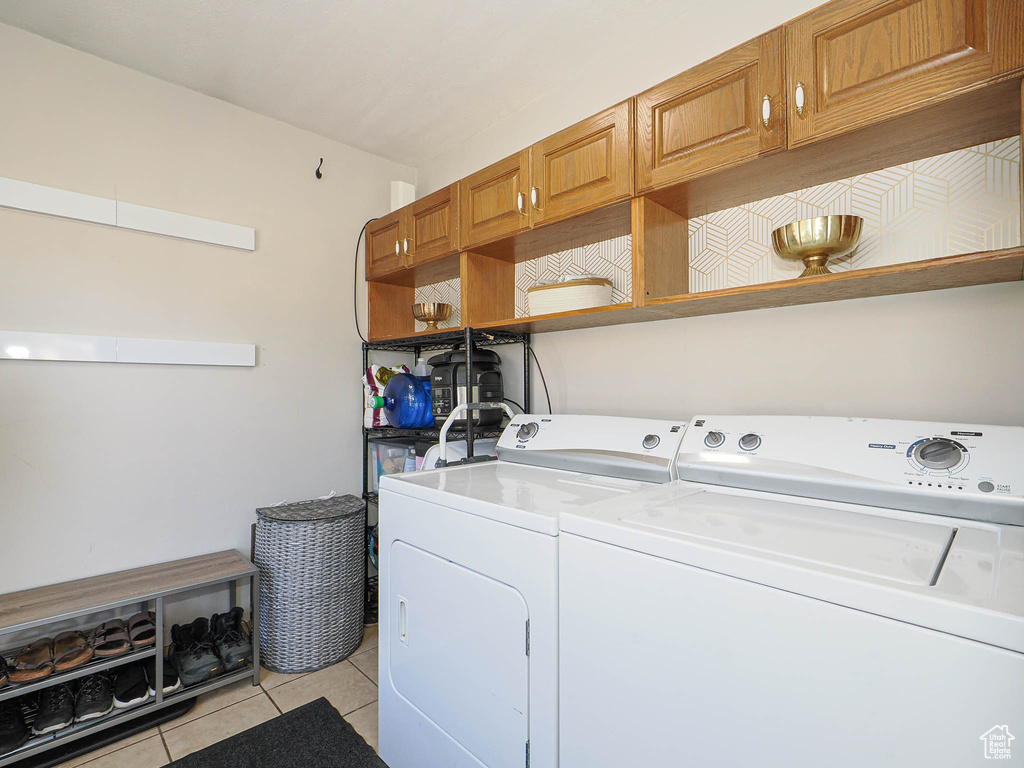 Laundry area featuring light tile patterned floors and washer and clothes dryer